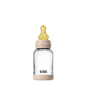 Clear baby bottle with beige cap and 'BIBS' branding on a white background