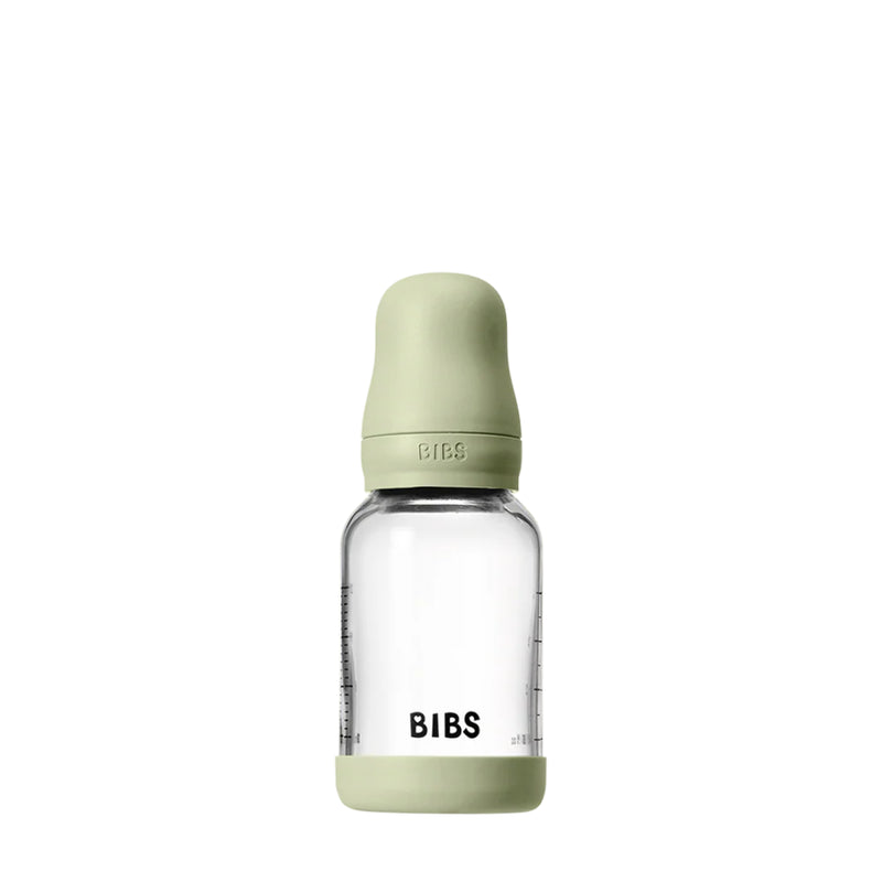 Clear baby bottle with green cap and 'BIBS' branding on a white background