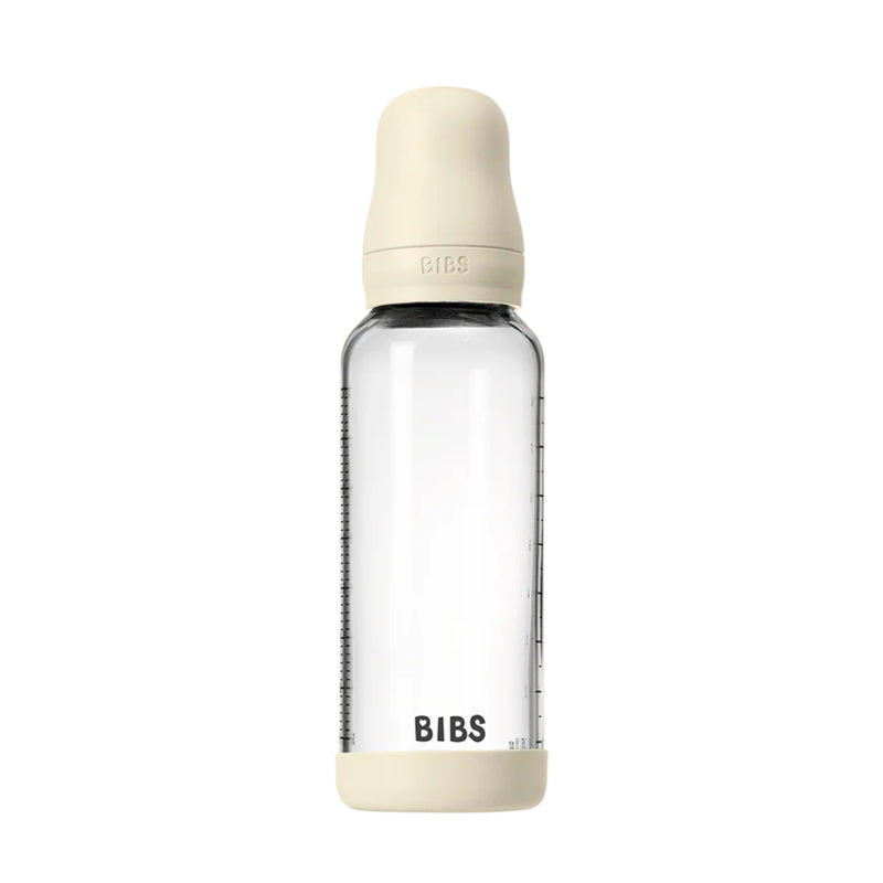 Clear baby bottle with beige cap and base on a white background