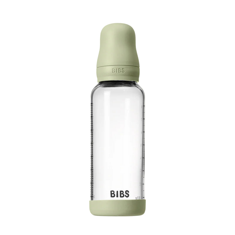 Clear baby bottle with green cap and base on a white background