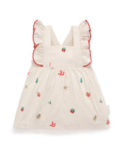 White dress with red trim and embroidered designs on a white background