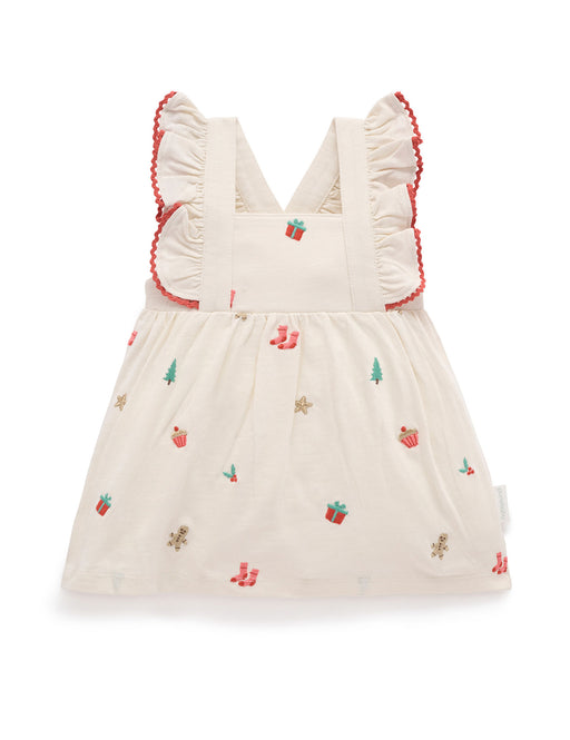White dress with red trim and embroidered designs on a white background